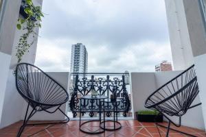 a balcony with two chairs and a table on a balcony at Habitación en Hospedaje Achalay, Qué lindo ! Qué bueno ! in Santa Fe