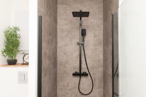 a shower with a shower head in a bathroom at L'Elégant des Remparts, vue sur chateau fort in Sedan