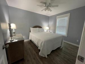 una camera con letto bianco e ventilatore a soffitto di 5313 Viking a Pensacola