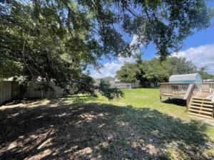 un cortile ombreggiato con una panchina e un albero di 5313 Viking a Pensacola