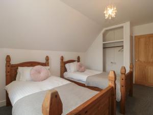 a bedroom with two beds with pink pillows at Primrose Cottage in Watchet