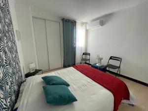 una camera con un letto con due cuscini verdi di Bel appartement T2 climatisé, centre de Banyuls, à 200m de la plage - FR-1-309-29 a Banyuls-sur-Mer Altre 2 foto