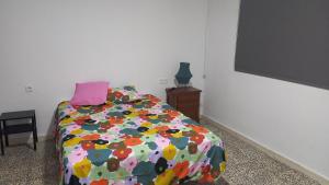a bedroom with a bed with a colorful comforter at Casa del Prendi in Jerez de la Frontera
