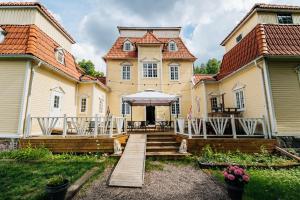 a large house with a porch and a deck at Glampingtält i naturen in Molkom