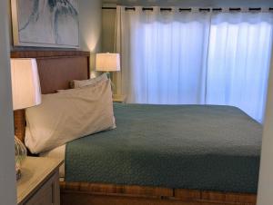 a bedroom with a bed with two lamps and a window at Gulf Side Villa 1B in Pensacola