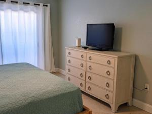 a bedroom with a dresser with a television on it at Gulf Side Villa 1B in Pensacola