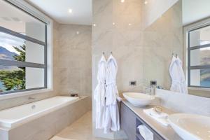 a bathroom with a tub and a sink and a bath tubermott at Lake Views at Aspen House by Amazing Accom in Queenstown