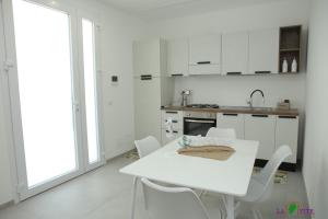 a white kitchen with a white table and chairs at La Vite in Locogrande +51 photos