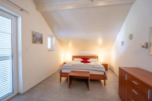 a bedroom with a bed with red pillows on it at Apartman Ivka in Rakovica +14 photos