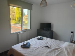 a bedroom with a bed with two slippers on it at Chez Katty in Régusse