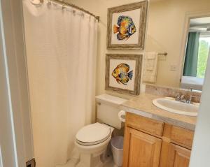 a bathroom with a toilet and a sink at Tequila Sunrise in Pensacola +27 photos