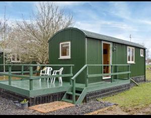 a green shipping container house with a deck at Squirrels-oaks in Yalding
