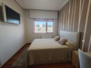 een kleine slaapkamer met een bed en een raam bij 2 habitaciones en piso Bilbao in Bilbao