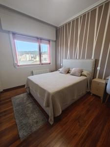 een slaapkamer met een bed en een raam bij 2 habitaciones en piso Bilbao in Bilbao