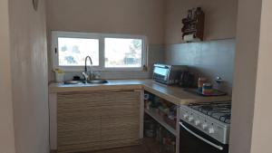 a small kitchen with a sink and a stove at El descanso in Gardey