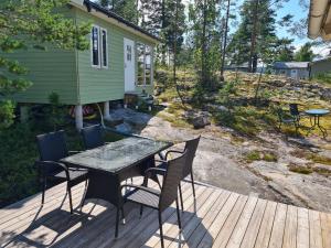 a patio with a table and chairs on a deck at Gäststuga Norafjärden in Sandöverken