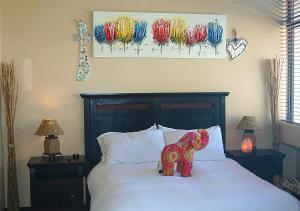 a toy elephant sitting on top of a bed at U PRIVATE STUDIO apartment in Gardens Centre in Cape Town