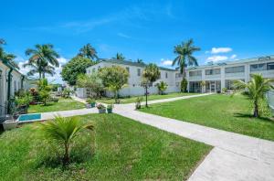 an exterior view of a building with palm trees at Americas Best Value Inn Historic Clewiston Inn in Clewiston