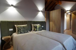 a bedroom with a large bed with two pillows at Refugio do Tempo in Beça