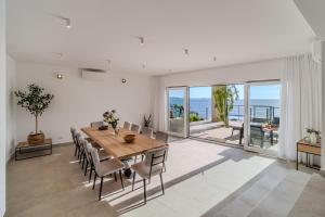 ein Esszimmer mit Tisch und Stühlen und dem Meer in der Unterkunft Villa Blue Horizon in Nerežišće