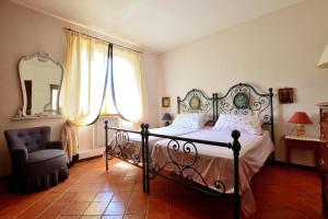 a bedroom with a bed and a chair and a mirror at Country house Il Poggio in Otricoli