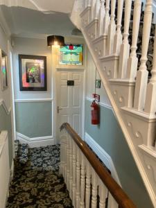 a hallway with a staircase with a white stair case at ParkRoyal Blackpool in Blackpool