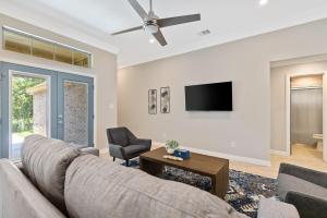Una sala de estar con un sofá y un televisor. en Lulu Living, en Fort Worth