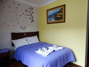a bedroom with a blue bed with two towels on it at Casa Hospedaje Teresita in Chachapoyas +18 photos