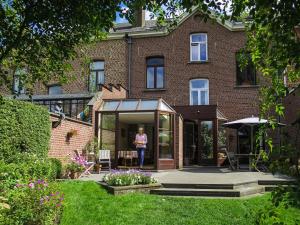 a woman standing in front of a house at B&B Woluwé - lits en mezzanine in Brussels