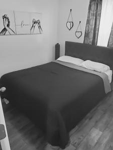 a black and white bedroom with a bed and some drawings on the wall at Cozy Nest: Where Love Blossoms in Nashville