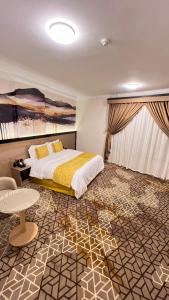 a bedroom with a bed and a table in it at Capital Guest hotel in Makkah
