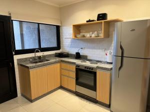 eine Küche mit Herd und Kühlschrank in der Unterkunft Exclusive Dúplex Iguazú in Puerto Iguazú
