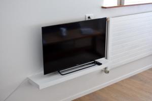 a flat screen tv hanging on a wall at Natura Apartments in Laugar