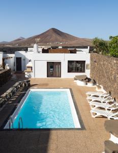 a house with a swimming pool and some chairs at Villa Estrella Polar in Tahiche