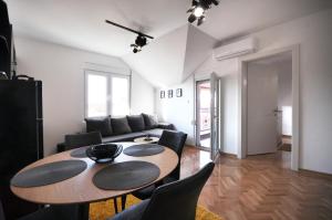 a living room with a table and a couch at Apartman Chaplin in Vrnjačka Banja +13 photos