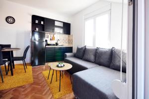 a living room with a couch and a table and a kitchen at Apartman Chaplin in Vrnjačka Banja