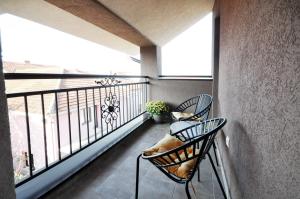 a balcony with two chairs and a dog laying on it at Apartman Chaplin in Vrnjačka Banja