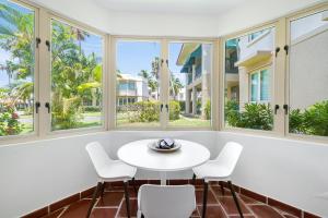 a room with windows and a white table and chairs at Quaint villa Beach access Elina in Sabana