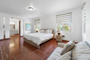 a white bedroom with a bed and a couch at Quaint villa Beach access Elina in Sabana