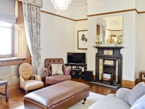 ein Wohnzimmer mit Couch und Kamin in der Unterkunft Aberdeen Lighthouse Cottages - coastal, dolphins in Aberdeen + 34 Fotos