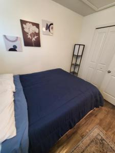 a bedroom with a bed with a blue blanket at Cozy Nest: Where Love Blossoms in Nashville