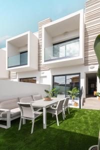 a house with a white dining table and chairs at Vivienda Las Arecas - El Médano in El Médano