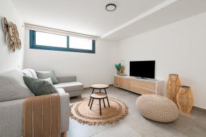 a living room with a couch and a tv at Vivienda Las Arecas - El Médano in El Médano