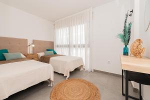 a hotel room with two beds and a window at Vivienda Las Arecas - El Médano in El Médano +10 photos