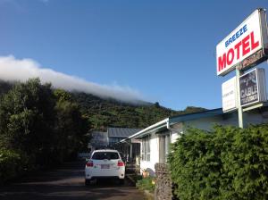 a white car parked in front of a motel at Breeze Motels in Greymouth