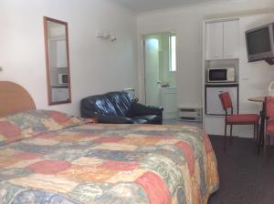 a hotel room with a bed and a chair at Breeze Motels in Greymouth