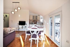 a kitchen and dining room with a table and chairs at Apartman Provansa in Vrnjačka Banja