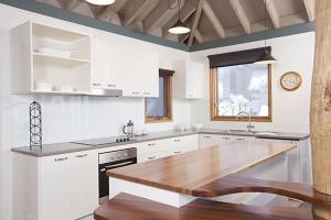 a large white kitchen with a wooden counter top at Eagles Nest in Mount Hotham