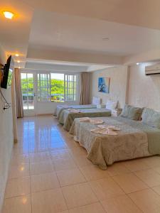 a hotel room with four beds and a flat screen tv at Residencial Portoveleiro in Cabo Frio