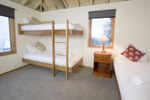 a bedroom with two bunk beds and a table with a lamp at Eagles Nest in Mount Hotham